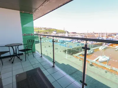 a balcony with a table and a view of a harbor at Pears Suite in Whitehaven