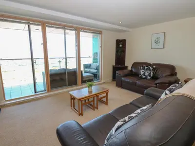 a living room with a leather couch and a table at Pears Suite in Whitehaven