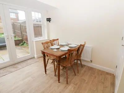a dining room with a wooden table and chairs at Lingla House in Frizington