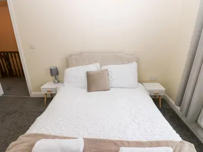 a bed with white sheets and pillows in a room at Lingla House in Frizington