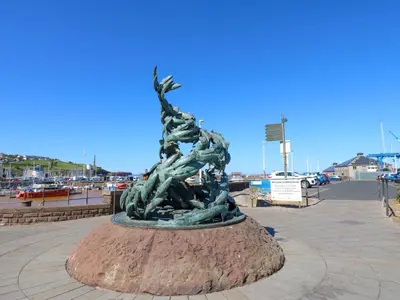 a statue of two people standing on a mound at Lowther Apartment in Whitehaven