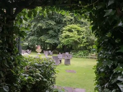 a row of chairs in a park with trees at Coleridge in Ambleside