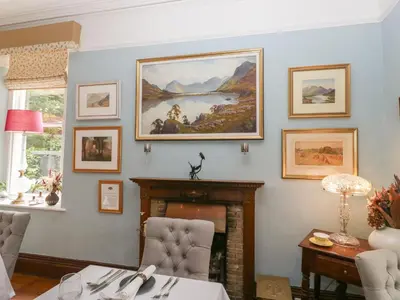 a living room with a fireplace and a painting on the wall at Dorothy in Ambleside