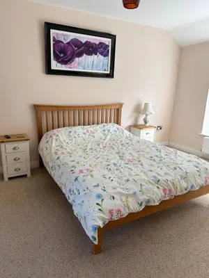 a bedroom with a bed and a picture on the wall at Lower Milntown Farm in Ramsey