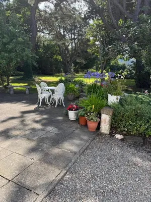a garden with two chairs and flowers and plants at Lower Milntown Farm in Ramsey