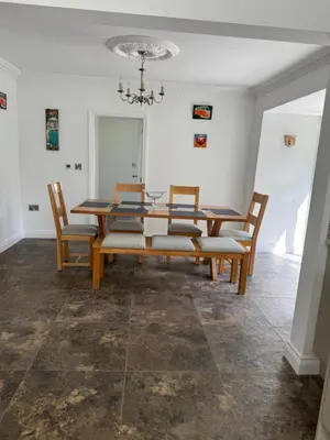 a dining room with a wooden table and chairs at Lower Milntown Farm in Ramsey