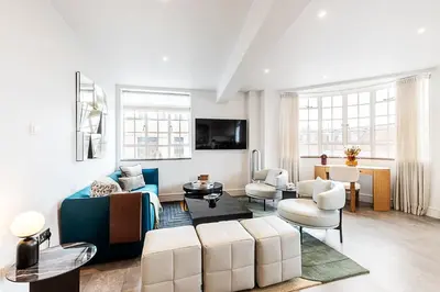 a living room with a couch and a table at Stylish Chelsea Flat Near Sloane Square in Moffat
