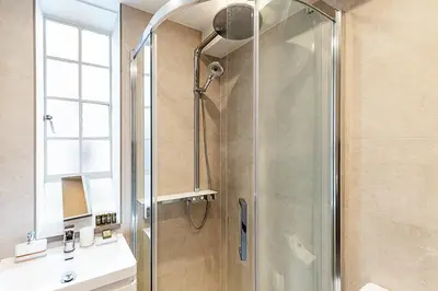 a bathroom with a shower and a sink at Stylish Chelsea Flat Near Sloane Square in Moffat