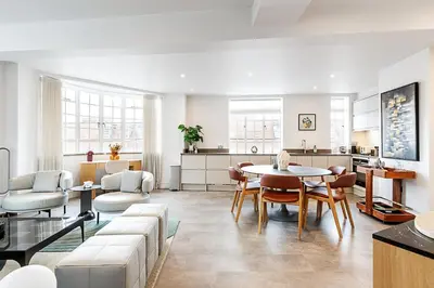 a living room with a couch and a table at Stylish Chelsea Flat Near Sloane Square in Moffat