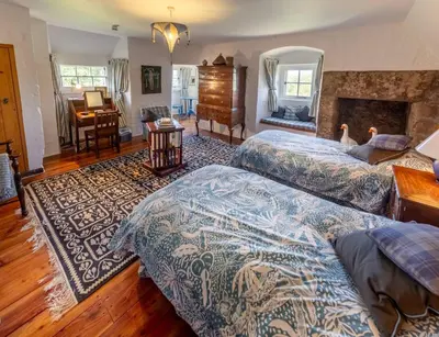 a bedroom with two beds and a fireplace at Spedlins Castle in Templand