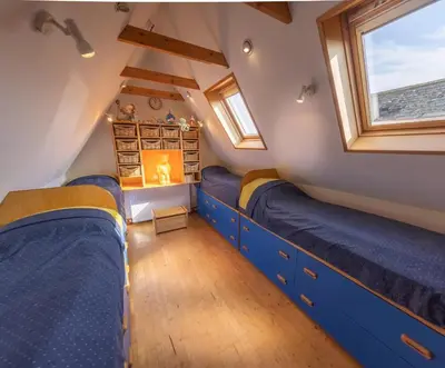 a bedroom with blue bunk beds in a attic at Spedlins Castle in Templand