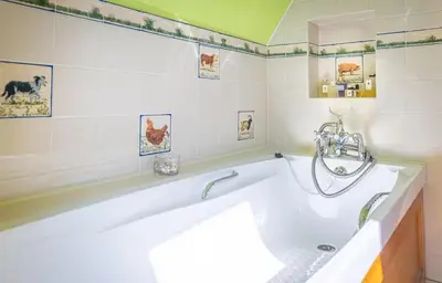 a bath tub in a bathroom with green walls at Spedlins Castle in Templand