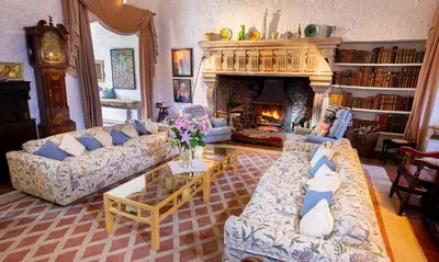 a living room with two couches and a fireplace at Spedlins Castle in Templand