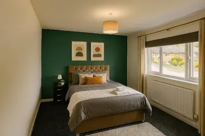a green bedroom with a bed and a window at Near West Cumbria Hospital in Whitehaven