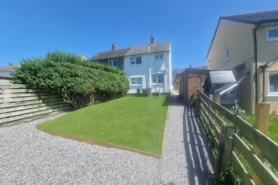 a backyard of a house with a grass yard at Near West Cumbria Hospital in Whitehaven