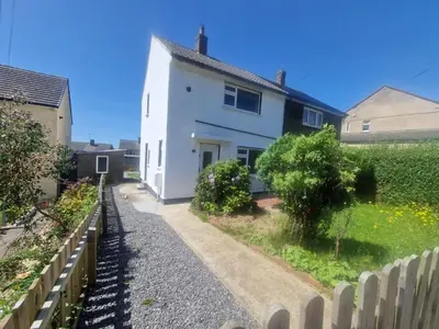 a white house with a fence in front of it at Near West Cumbria Hospital in Whitehaven