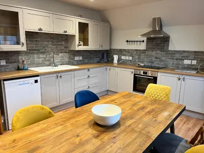 a kitchen with a wooden table and yellow chairs at Wheatsheaf Flat