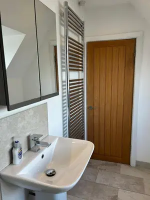 a bathroom with a white sink and a wooden door at Wheatsheaf Flat