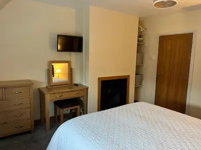 a bedroom with a bed and a dresser with a mirror at Wheatsheaf Flat