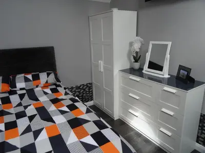 a bedroom with a bed and a dresser with a mirror at Lazy Lodge in Foxdale