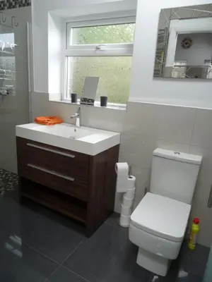 a bathroom with a sink and a toilet and a window at Lazy Lodge in Foxdale