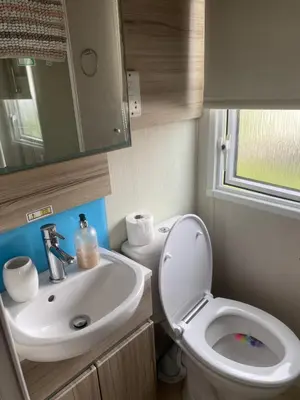 a small bathroom with a toilet and a sink at surfshack caravan MH19D manor house park in Mawbray