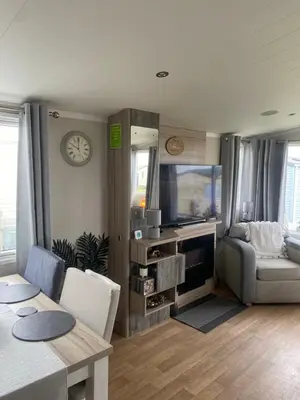 a living room with a table and a dining room at surfshack caravan MH19D manor house park in Mawbray