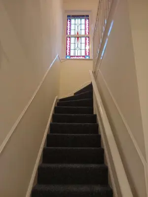 a staircase with a stained glass window at Double Ensuite - City centre homestay - Peterill Room - in Carlisle