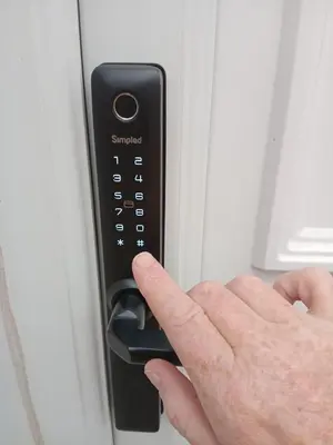 a person pressing a remote control on a refrigerator at Double Ensuite - City centre homestay - Peterill Room - in Carlisle