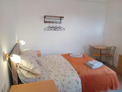 a bedroom with a bed and a table and chairs at Double Ensuite - City centre homestay - Peterill Room - in Carlisle