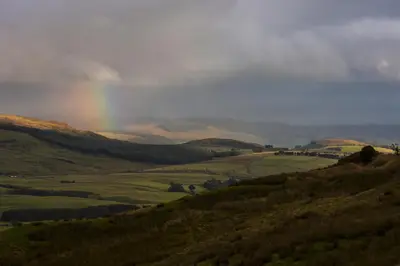 a rainbow in the sky over a green valley at Moffat Manor Holiday Resort in Beattock