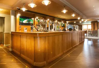 a bar in a pub with a wooden wall at Moffat Manor Holiday Resort in Beattock