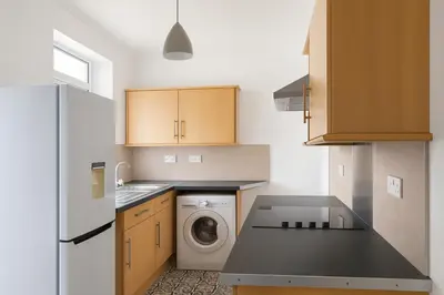 a kitchen with a washing machine and a washer at Coastal Haven - Steps From Beach in Whitehaven
