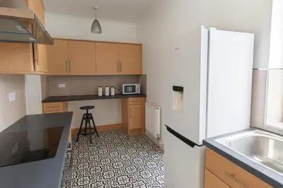 a small kitchen with a refrigerator and a sink at Coastal Haven - Steps From Beach in Whitehaven