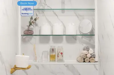 a glass shelf in a bathroom with toiletries at Cozy 4-Bedrooms House By Azzurri Properties Short Lets & Serviced Accommodation London With Private Garden, Wi-Fi in Moffat