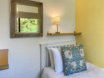 a bedroom with a mirror and a bed with a pillow at 3 Laigh Isles in Kirkcudbright
