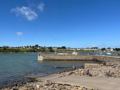 a body of water with a dock in the water at 3 Laigh Isles in Kirkcudbright