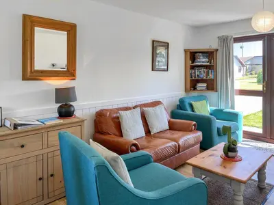 a living room with a couch and two chairs at 3 Laigh Isles in Kirkcudbright