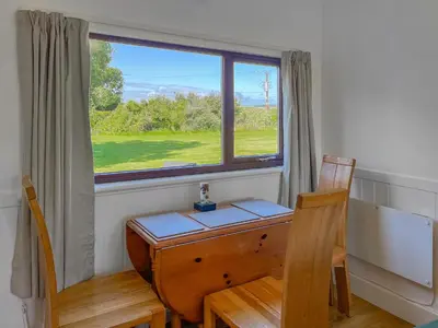 a desk and two chairs in a room with a window at 3 Laigh Isles in Kirkcudbright