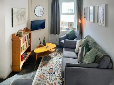 a living room with two couches and a table at Hideaway Cottage in Keswick