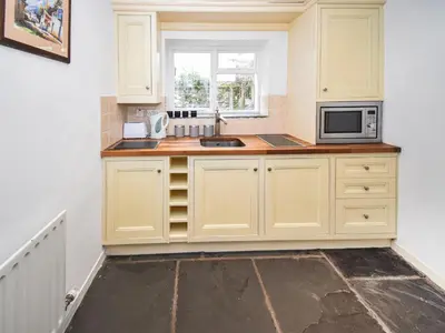 a kitchen with a sink and a microwave at Hideaway Cottage in Keswick