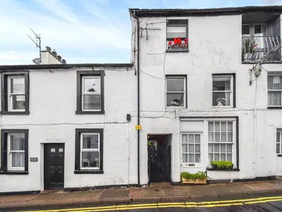 a white building with windows and flowers in a window box at Hideaway Cottage in Keswick