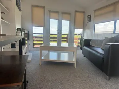a living room with a couch and a coffee table at Bowmore 7 - Stunning Sea Views, Farm Stay in Stranraer