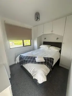 a bedroom with two beds and a window at Bowmore 7 - Stunning Sea Views, Farm Stay in Stranraer