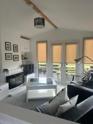 a living room with a couch and a table at Bowmore 7 - Stunning Sea Views, Farm Stay in Stranraer