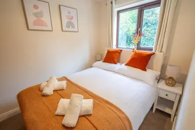 a bedroom with a bed with orange pillows on it at 2 Bed, Ground Floor Flat, Carlisle in Carlisle