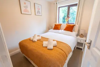 a bedroom with a large bed with towels on it at 2 Bed, Ground Floor Flat, Carlisle in Carlisle