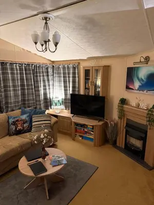 a living room with a couch and a tv at The West Lakes Caravan in Lamplugh