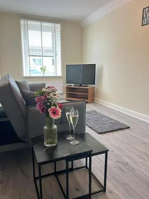 a living room with a couch and a table with wine glasses at Birks Terrace - 2 Bedroom - Sleeps 4 in Cleator Moor