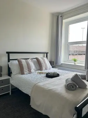 a bedroom with a large white bed with a window at Birks Terrace - 2 Bedroom - Sleeps 4 in Cleator Moor
